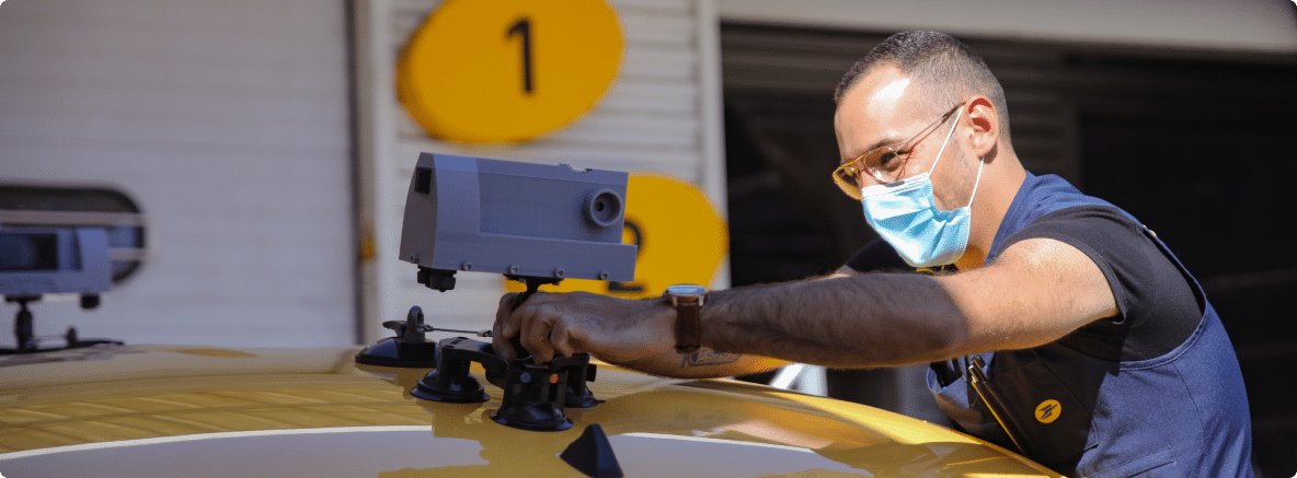 Facteur plaçant un capteur sur son véhicule